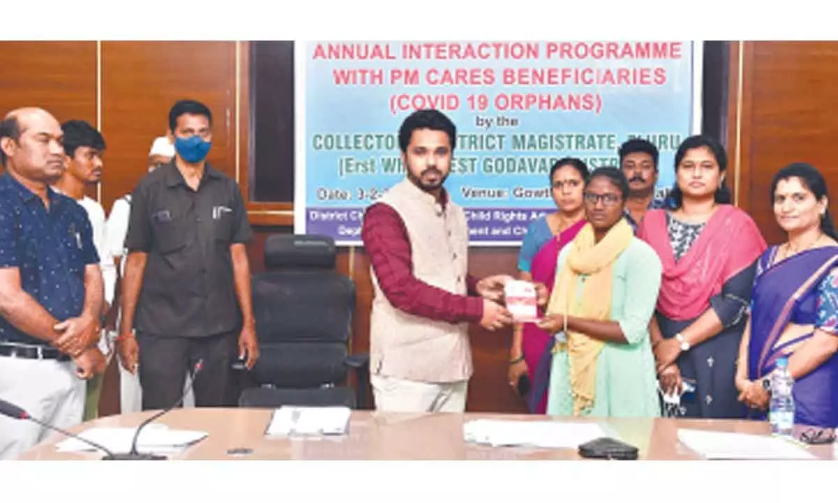 District Collector V Prasanna Venkatesh handing over financial help to a PM-CARES beneficiary at a programme at the Collectorate in Eluru on Friday