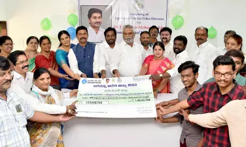 State Planning Board Chairman Malladi Vishnu and NTR district Collector S Dilli Rao presenting specimen cheque to the students in Vijayawada on Friday