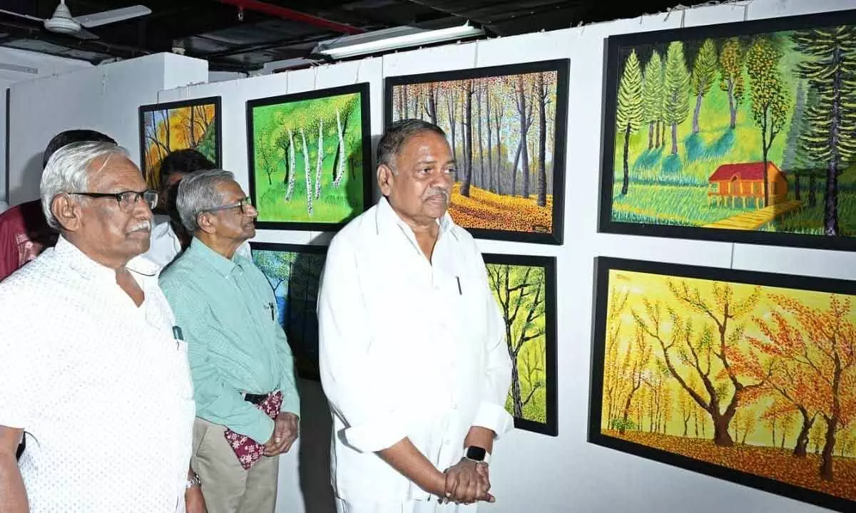 Former Assembly Deputy Speaker Mandali Buddha Prasad looking over the paintings at an exhibition at Cultural Centre in Vijayawada on Sunday