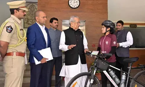Governor Biswabhusan Harichandan congratulating solo cyclist Aasha Malviya at Raj Bhavan in Vijayawada on Sunday