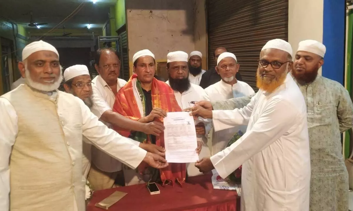 AP Haj Committee member Mohammed Basha handing over Haj application form to a pilgrim in Ongole on Wednesday