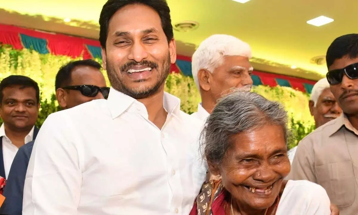 Chief Minister Y S Jagan Mohan Reddy poses with 80-year-old Venkatappamma of Yerraballi village in Pulivendula mandal on Wednesday