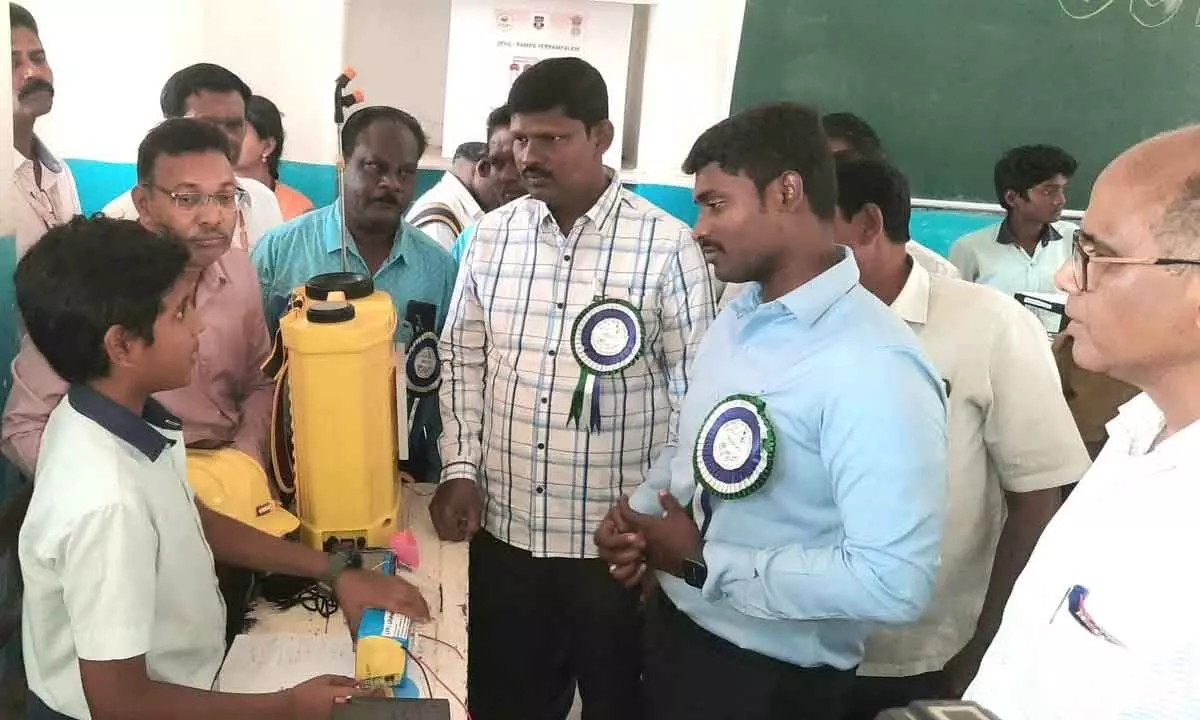 Students explaining projects to Municipal Commissioner K Dinesh Kumar and DEO Abraham at district-level science exhibition in Rajamahendravaram on Thursday