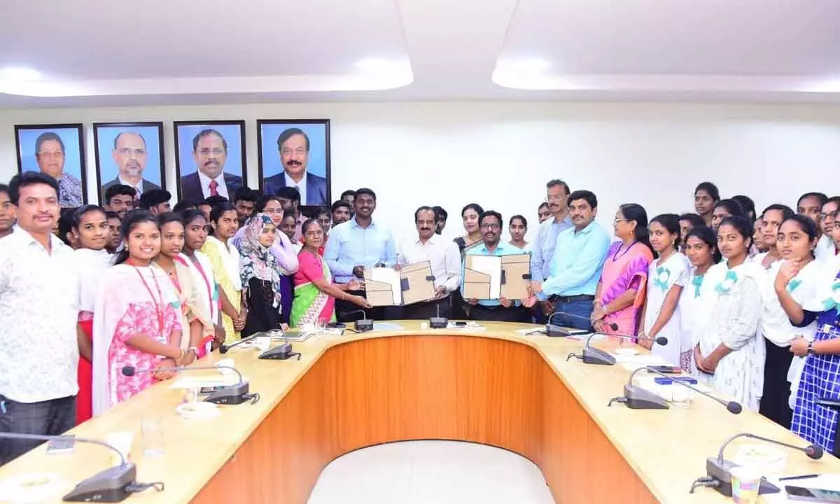 Municipal Commissioner Dinesh Kumar, Vice-Chancellor Prasada Raju and others exchanging MoU documents on waste management systems at ANU in Rajamahendravaram on Friday