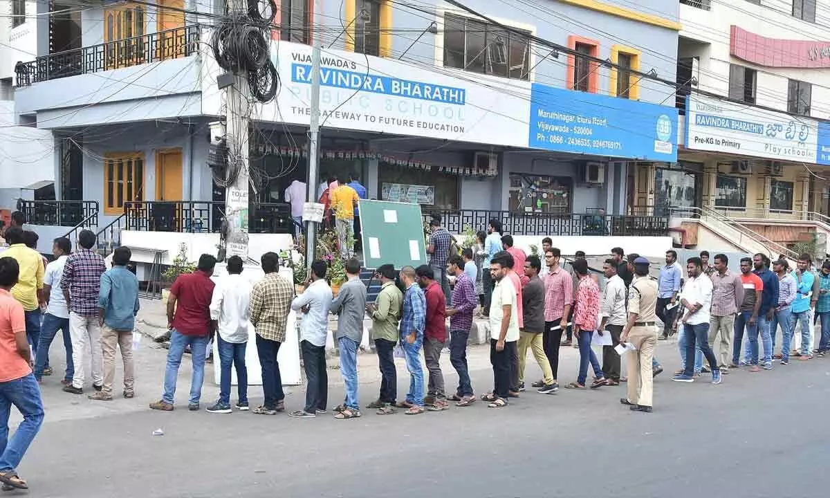 Candidates who have applied for SI posts standing in a queue line to enter into an examination centre in Vijayawada on Sunday 		 	Photo: Ch V Mastan
