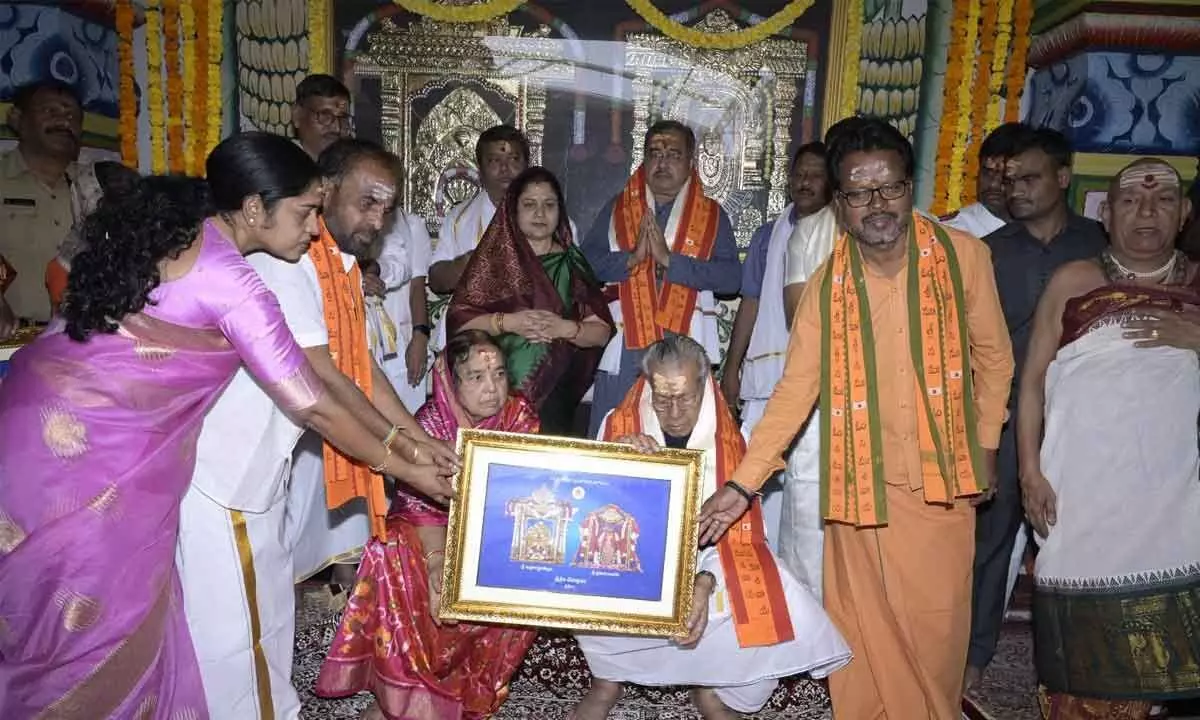 Srisailam temple officials present Governor couple with a portrait of the presiding deities and teertha prasadam on Monday