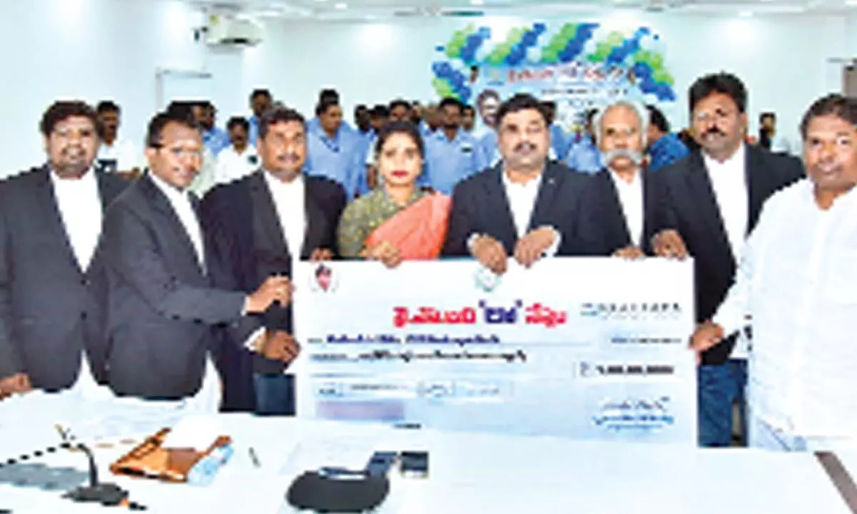 Krishna District Collector P Ranjith Basha handing over a specimen cheque to the beneficiaries at the Collectorate in Machilipatnam on Wednesday