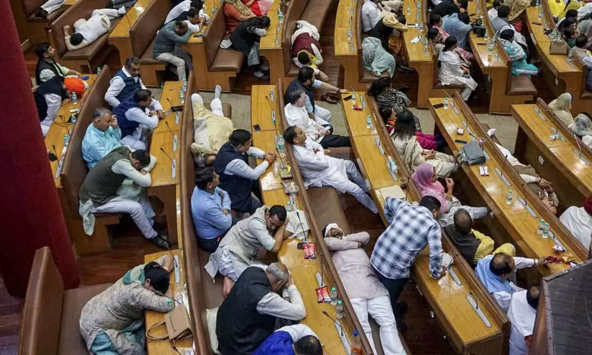 Councillors relax and sleep on the benches in the MCD  chamber after having stayed overnight, in New Delhi on Thursday