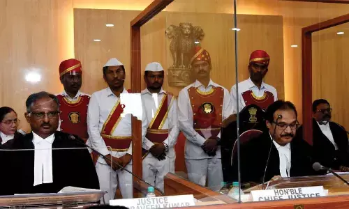 Chief Justice of AP High Court Justice Prashant Kumar Mishra speaking at a meeting organised in the court to bid farewell to Justice Praveen Kumar (left) on his superannuation