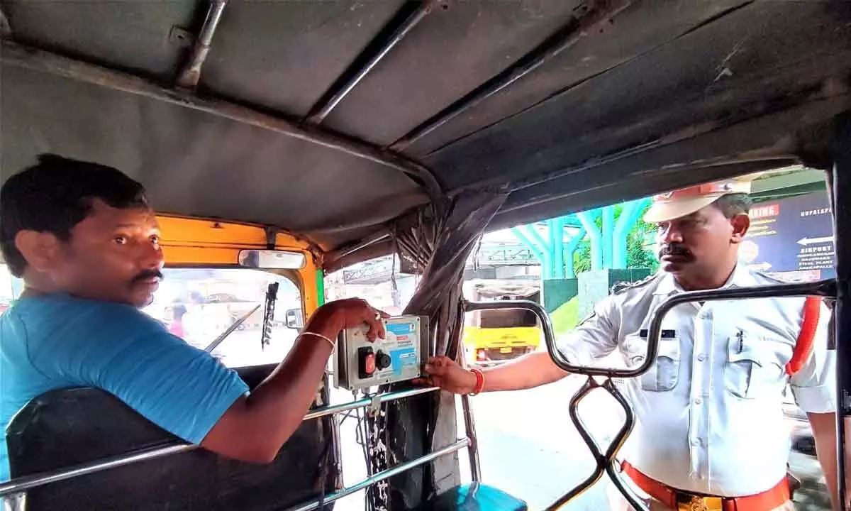 Traffic Circle Inspector M Apparao checking the Abhayam app in an auto rickshaw in Visakhapatnam