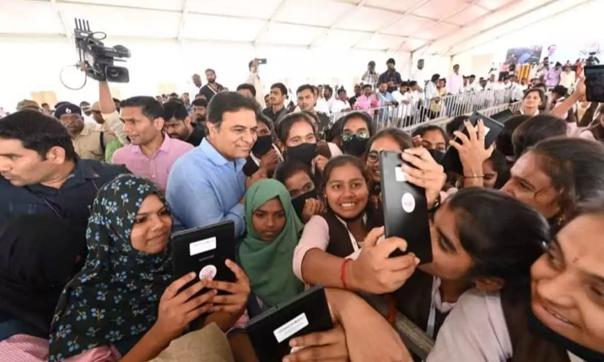 Minister KT Rama Rao taking a selfie with students at Yellareddypet in Sircilla district on Tuesday