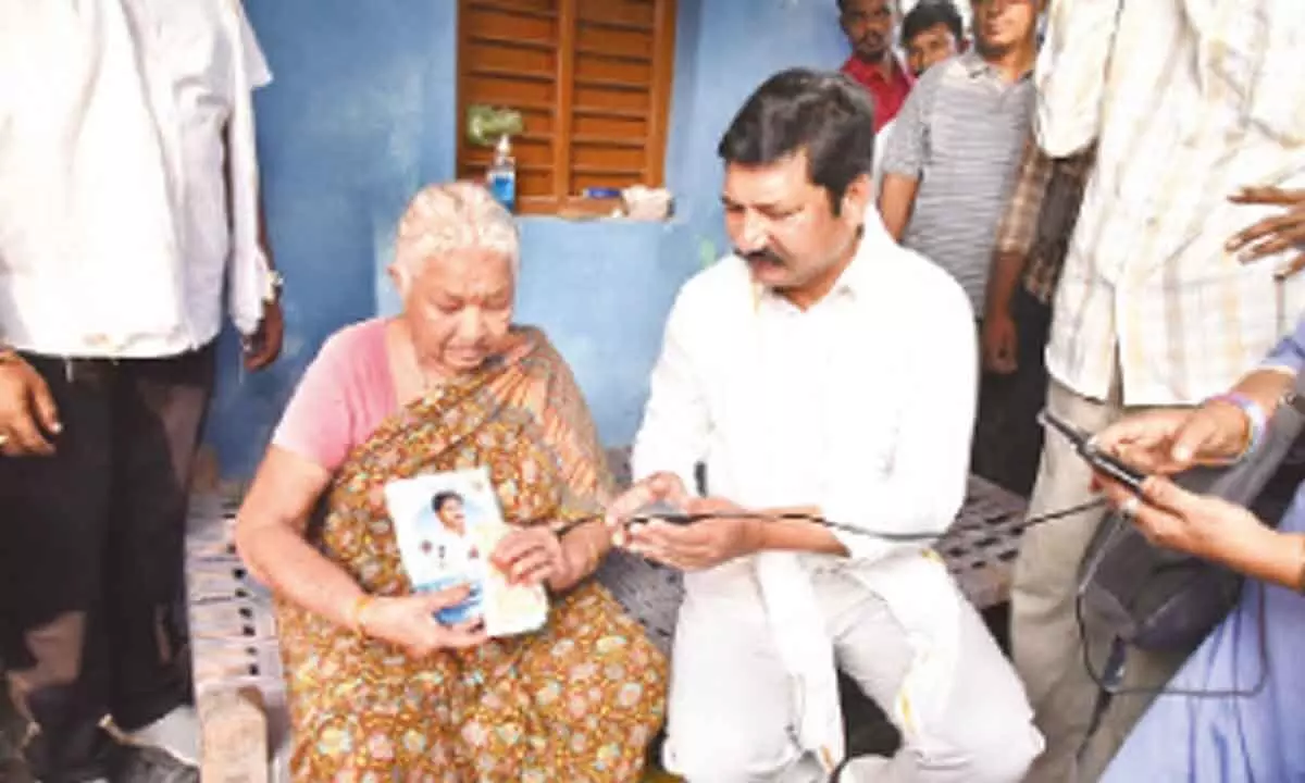 Housing Minister Jogi Ramesh handing over pension to a beneficiary at Pedana in Krishna district on Wednesday