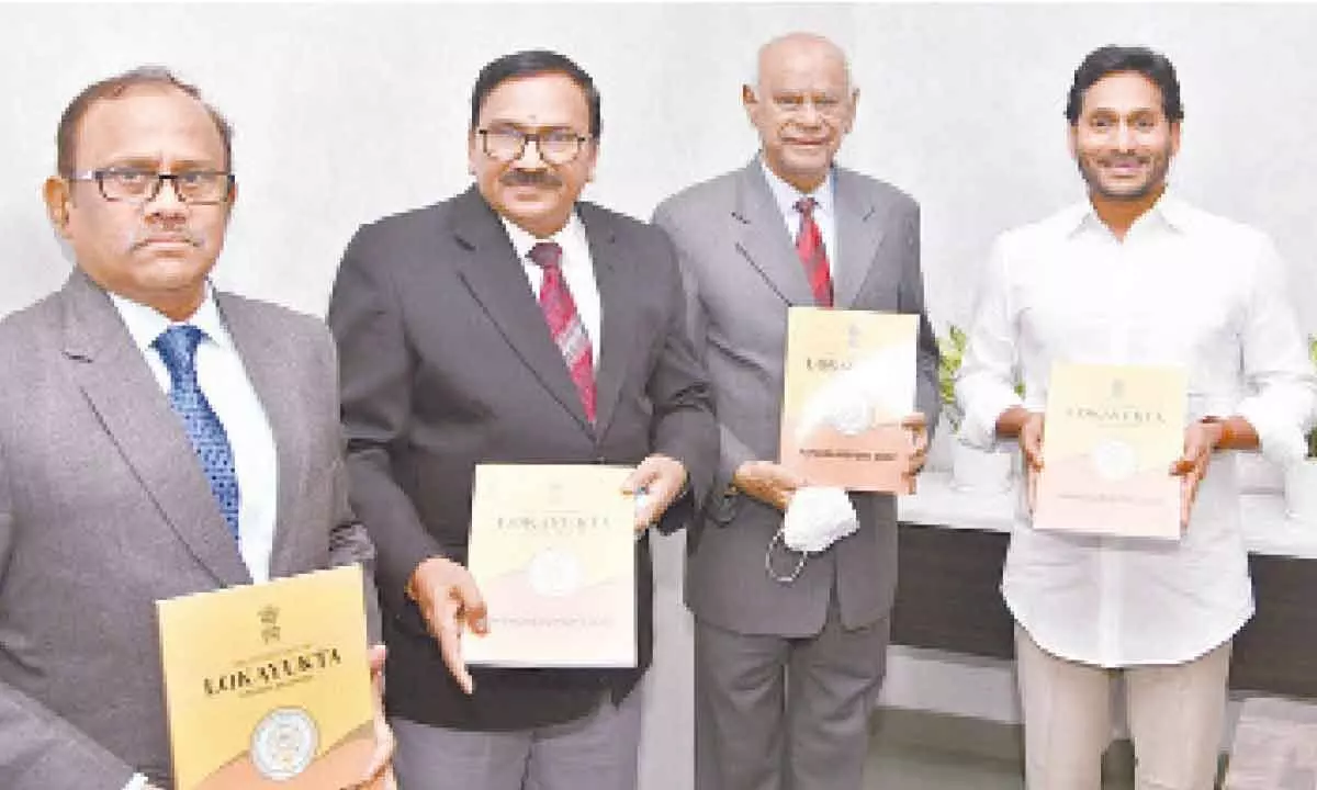 Andhra Pradesh Lokayukta Justice (Retd) P Lakshman Reddy (second from right) hands over AP Lokayukta annual report to Chief Minister Y S Jagan Mohan Reddy at his camp office in Tadepalli on Monday. Lokayukta officials are also seen.