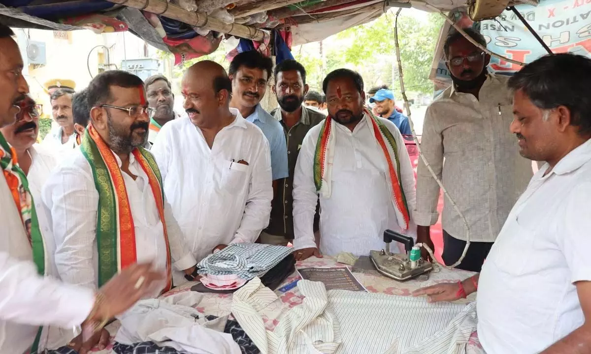 Hanumakonda DCC president Naini Rajender Reddy interacting with a launderer during his Hath Se Hath Jodo Yatra in Warangal West constituency on Tuesday