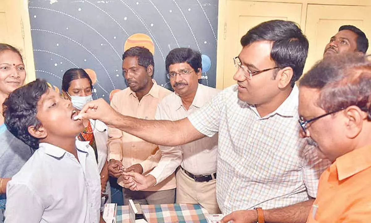 District Collector KVN Chakradhar Babu administering de-worming tablets to the students at DCR High School in Nellore on Tuesday