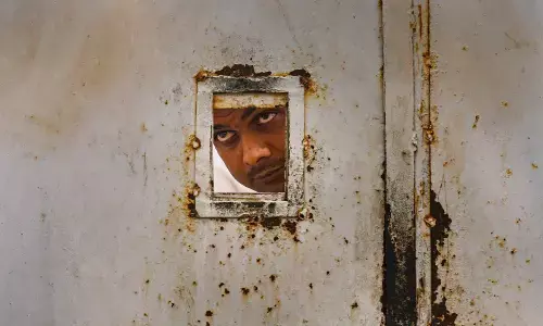 A security personnel looks outside from the residence of Congress leader Rahul Gandhi after police personnel reached the residence