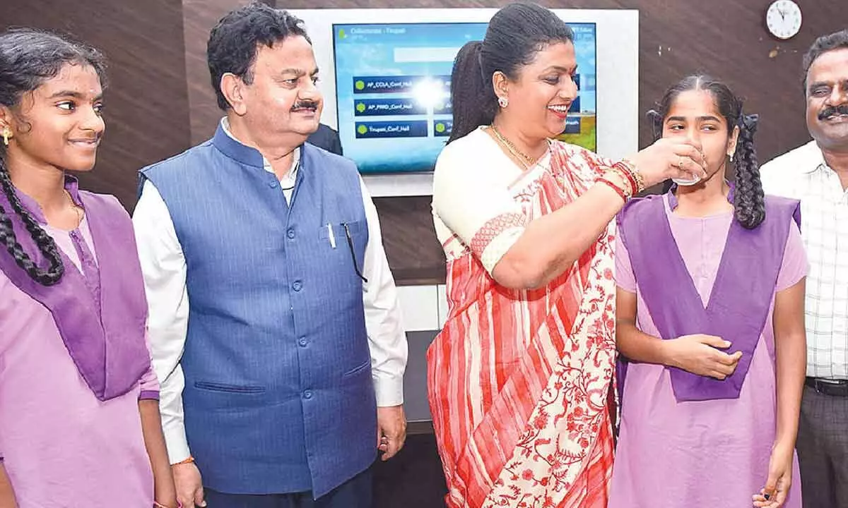 Minister RK Roja offering Ragi malt to a student at Tirupati Collectorate on Tuesday.  Collector K Venkataramana Reddy and DEO Dr V Sekhar are also seen.