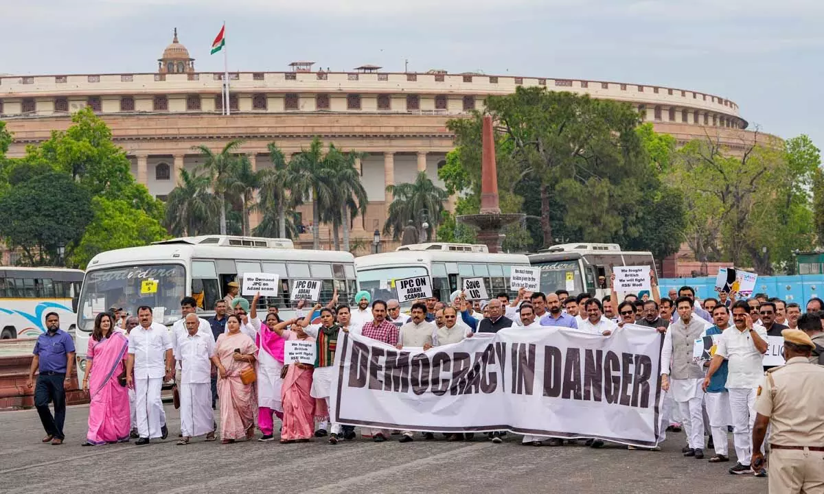 Congress President Mallikarjun Kharge and along with MPs of other like-minded opposition parties holds a “Democracy in Danger” banner during a protest march towards Rashtrapati Bhawan, in New Delhi on Friday
