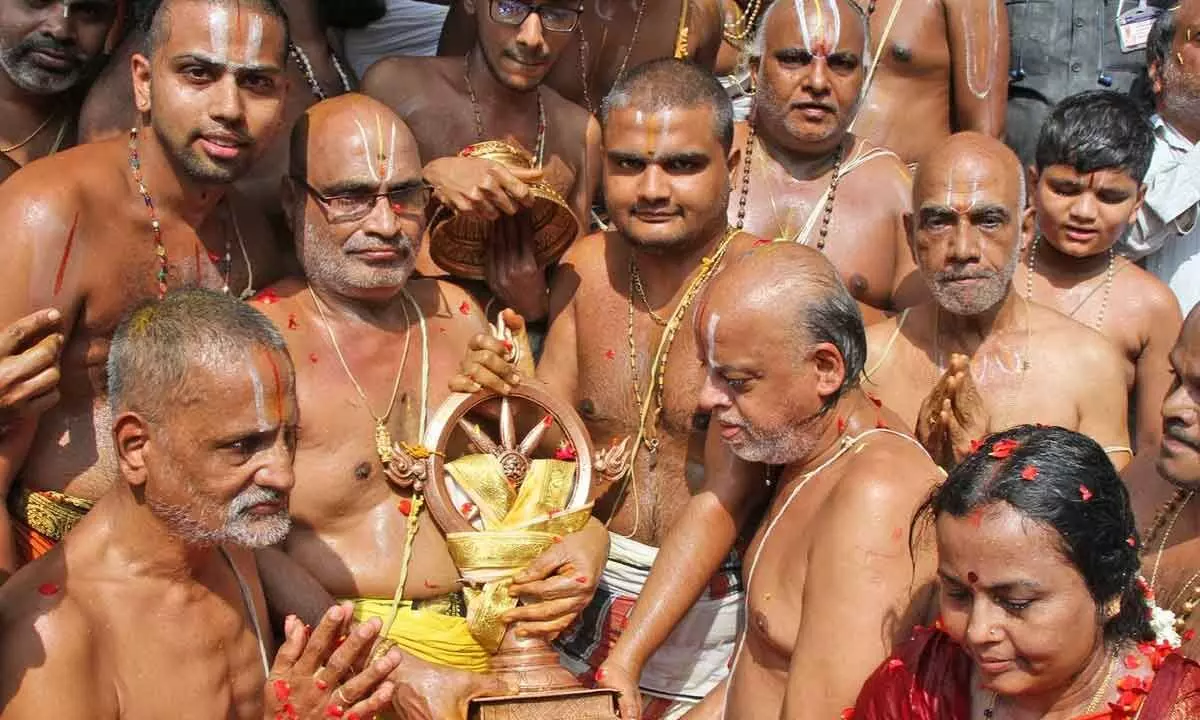Priests performing Chakrasnanam at Kapilatheertham on the last day of the annual Brahmotsavams of Sri Kodandarama Swamy temple in Tirupati on Tuesday
