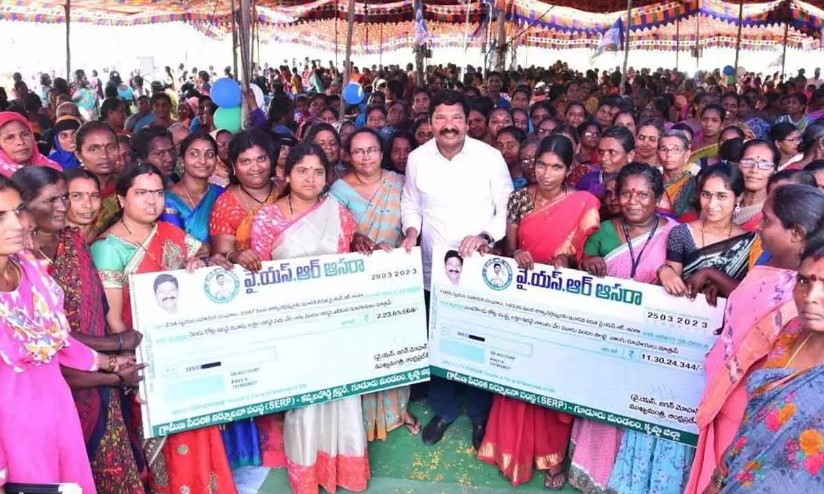 Minister Jogi Ramesh handing over cheques to SHG members at Kappaladoddi in Krishna district on Wednesday
