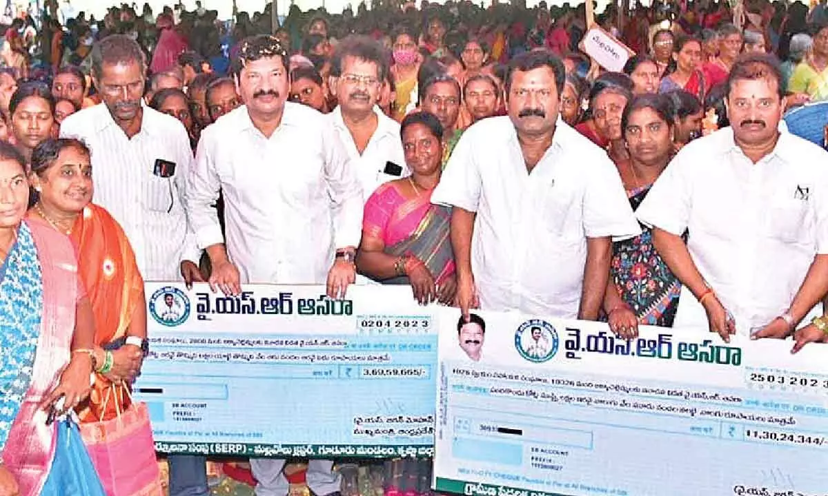 Housing Minister Jogi Ramesh and others distributing cheques to members of Self-Help Groups in Guduru mandal in Krishna district on Sunday