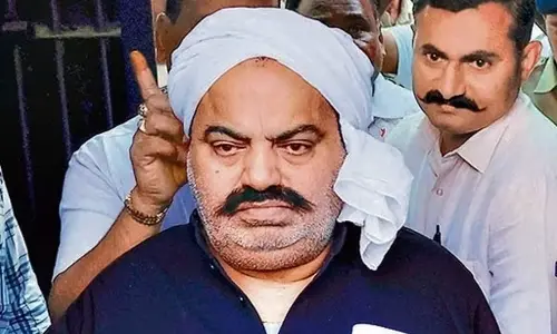 Prayagraj Police with jailed-mafia Atiq Ahmed outside Sabarmati Central Jail as he is being shifted to Prayagraj.