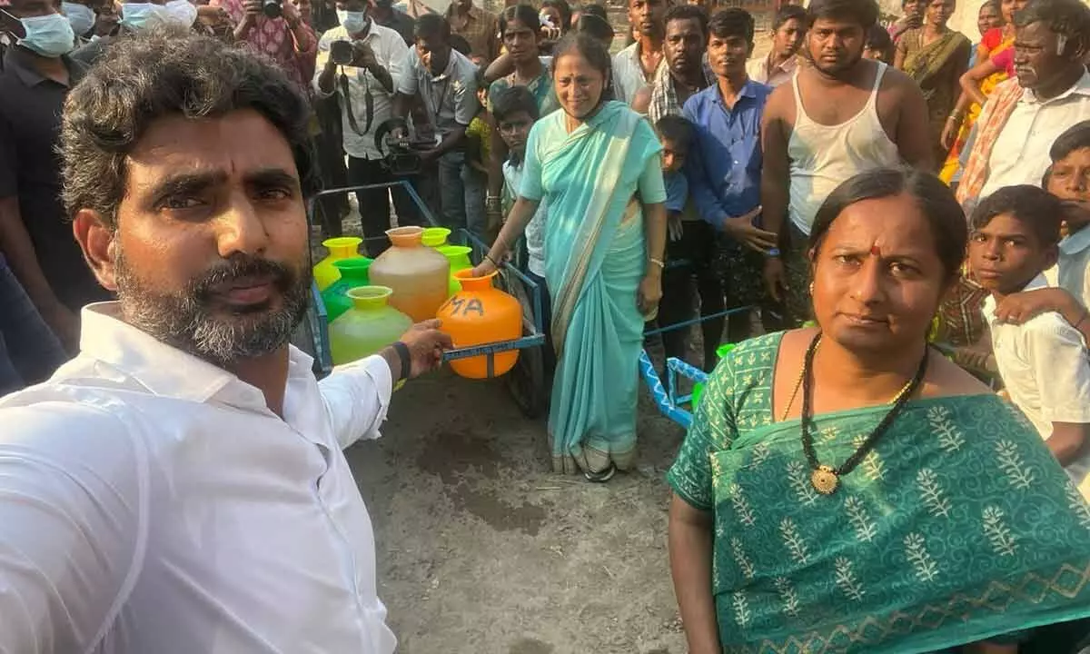 TDP national general secretary N Lokesh taking selfie at Karumanchi village where the people throng at a bore pump  to fetch a pot of water on Wednesday