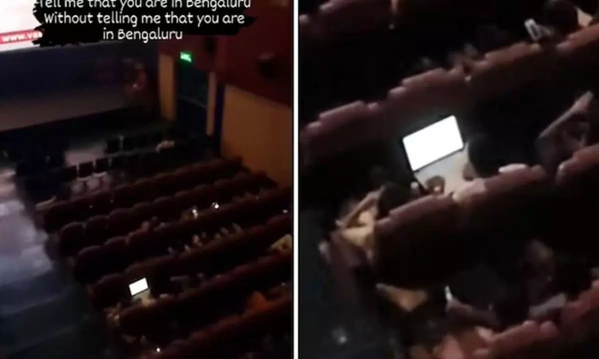 Man Working On Laptop While Watching Movie In Theatre