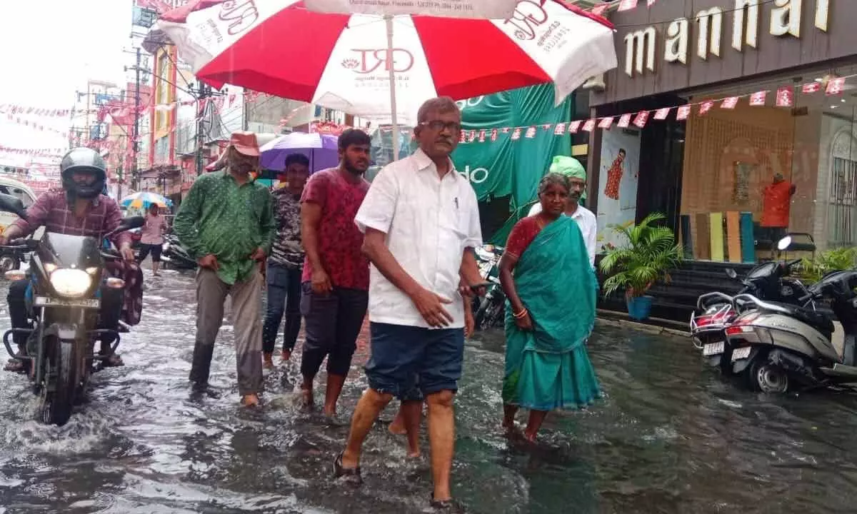 CPM leader Ch Babu Rao with CITU leaders wades in waterlogged Besant Road on Tuesday 						         Photo: Ch Venkata Mastan