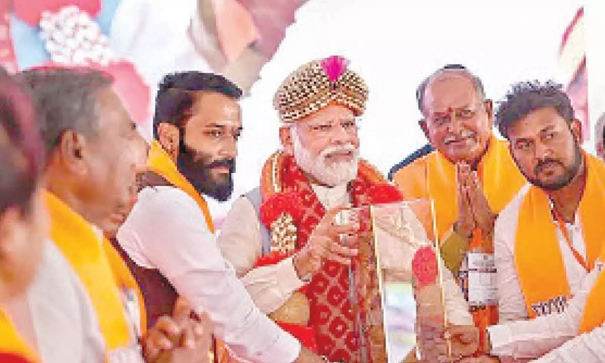 Prime Minister Narendra Modi being felicitated at an election campaign rally in favour of BJP candidates ahead of Assembly polls in Sindhanur on Tuesday