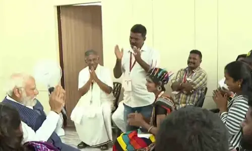 PM Modi interacting with members of Hakki Pikki tribe on Sunday in Shivamogga