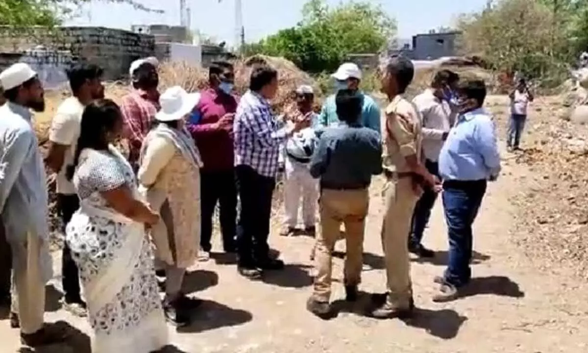 Officials speaking with the residents of Gonegandla after  studying the rock, which was split into two pieces due to  sweltering summer heat, on Wednesday.