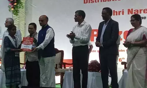 Union Minister of State for Finance Bhagwat Kishanrao Karad handing over an appointment letter to a candidate at the Rozgar Mela at Port Kalavani Stadium in Visakhapatnam on Tuesday