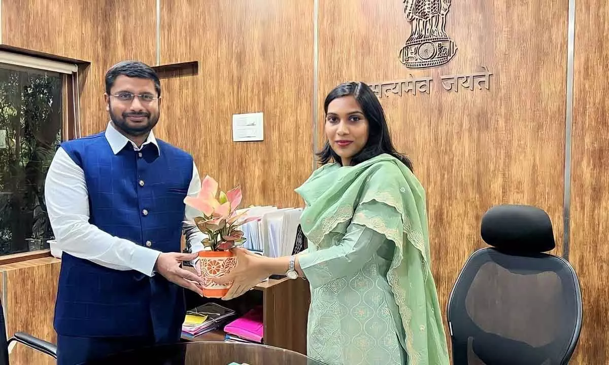 Rizwan Basha Shaik presenting a bouquet to the Warangal district collector P Pravinya in Hanumakonda on Sunday