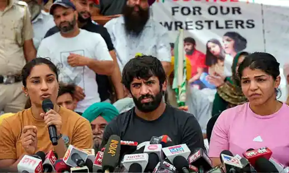 Wrestlers Sakshi Malik, Vinesh Phogat and Bajrang Punia speak with the media during their protest at Jantar Mantar in New Delhi, (PTI)