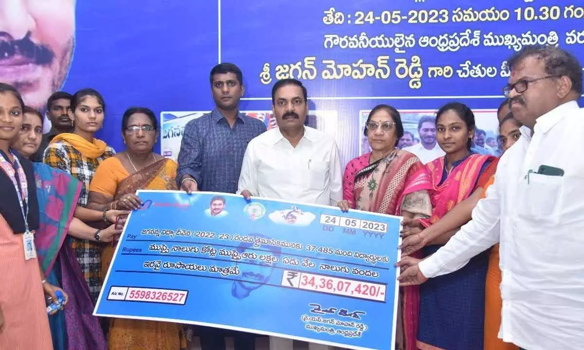 Agriculture Minister Kakani Govardhan Reddy handling over the cheque to the beneficiaries in Nellore on Wednesday