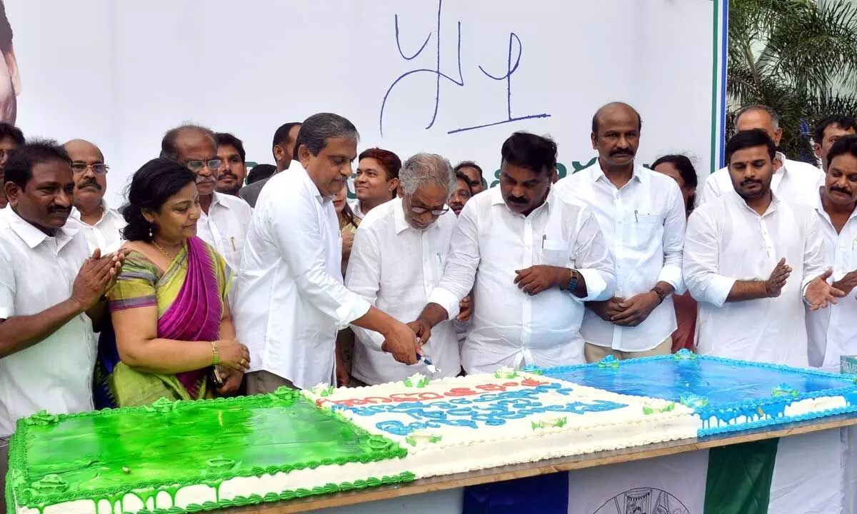 Government advisor (public affairs) Sajjala Ramakrishna Reddy, minister for social welfare Merugu Nagarjuna MLC and chief whip in Legislative Council Ummareddy Venkateswarlu cut the cake to mark the completion of four years of YSRCP government at the party central office in Tadepalli on Tuesday. Party leaders and public representatives of the party are also seen.  Photo: Ch Venkata Mastan