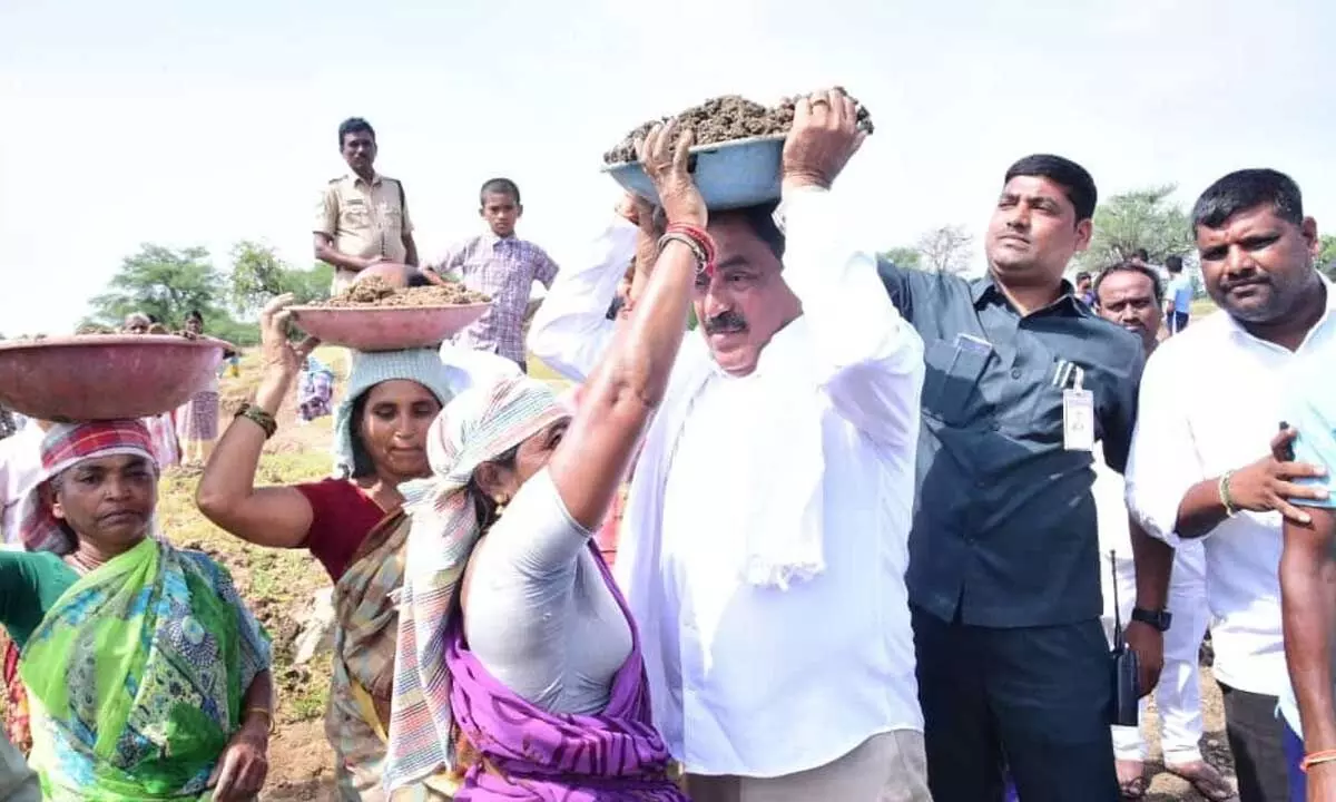 Minister of Panchayat Raj and Rural Development Errabelli Dayakar Rao speaking to MGNREGS workers by helping them in the labour at Ghatikal under Raiparthy mandal in Warangal district  on Monday