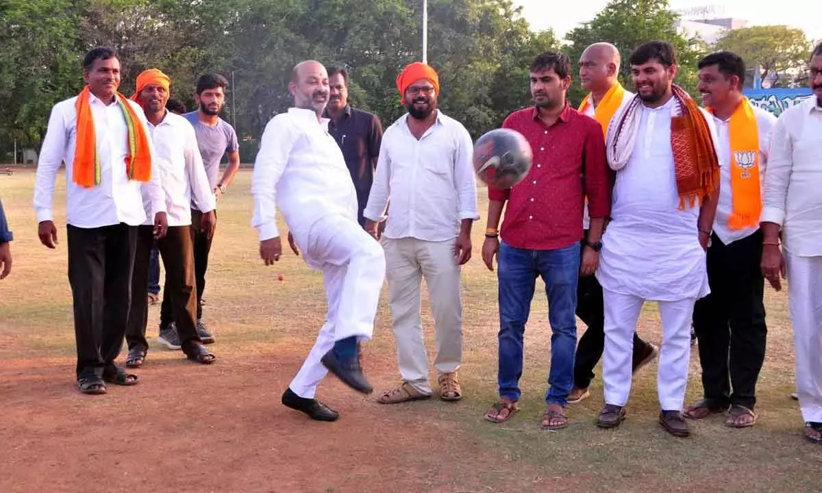 BJP leader playing football with children at SR&BGNR Grounds on Friday.