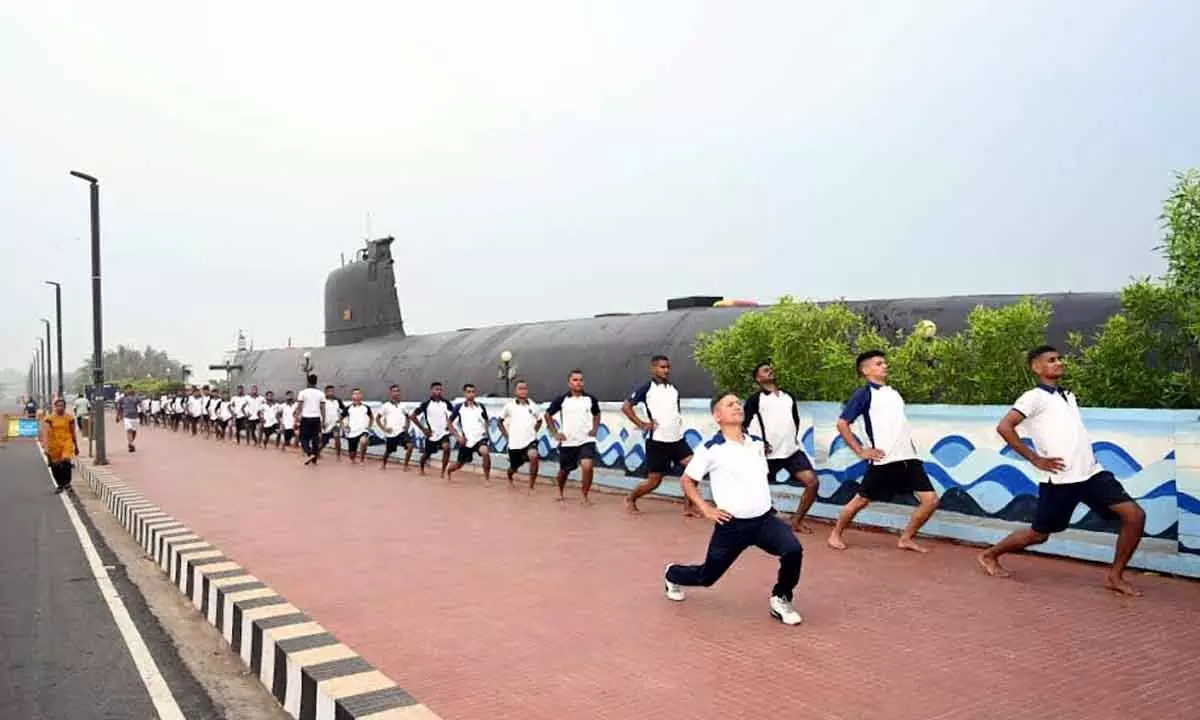 Naval personnel taking part in a yoga session organised near INS Kursura Submarine Museum at RK Beach in Visakhapatnam.