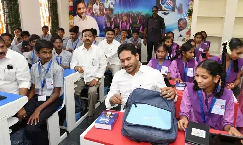 Chief Minister Y S Jagan Mohan Reddy sits in classroom after launching the distribution of Jagananna Vidya Kanuka kits at Model School in Krosuru on Monday
