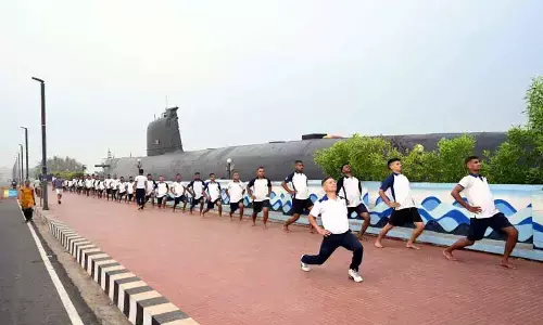 Naval personnel taking part in a yoga session organised near INS Kursura Submarine Museum at RK Beach in Visakhapatnam.