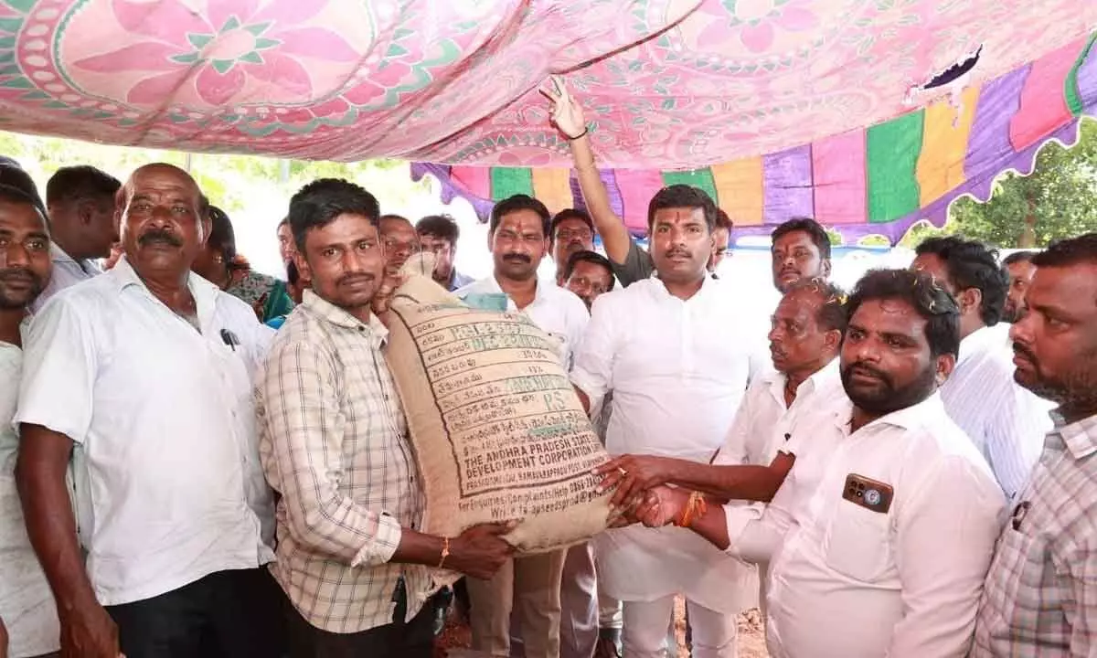 IT Minister G Amarnath distributing seeds to a farmer in Anakapalli district on Tuesday