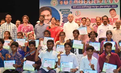 BC Welfare, I & PR Minister Chelluboyina Srinivasa Venugopala Krishna, District Collector Dr K Madhavi Latha and others with the students who received cash awards at the Jagananna Animutyalu programme in Rajamahendravaram on Saturday
