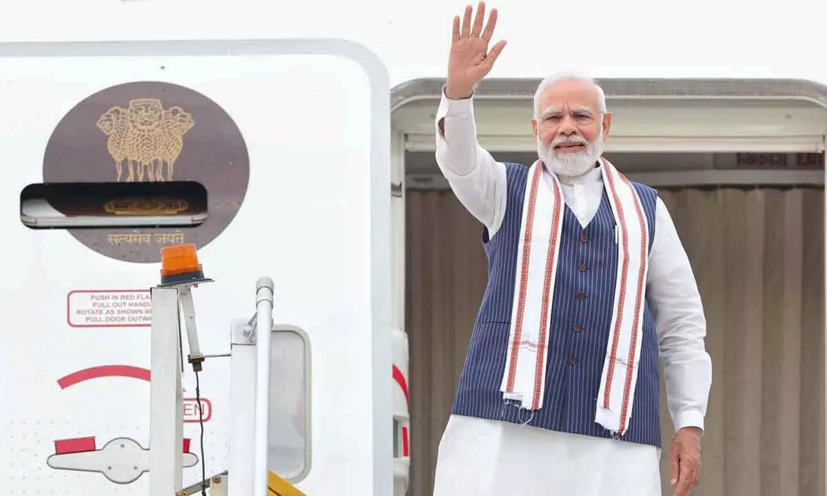 Prime Minister Narendra Modi waves while leaving for his visit to the United States, in New Delhi on Tuesday