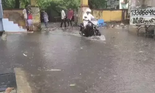 Vehicles wade through waterlogged road at Tahsildar’s office in Gurazala town on Wednesday