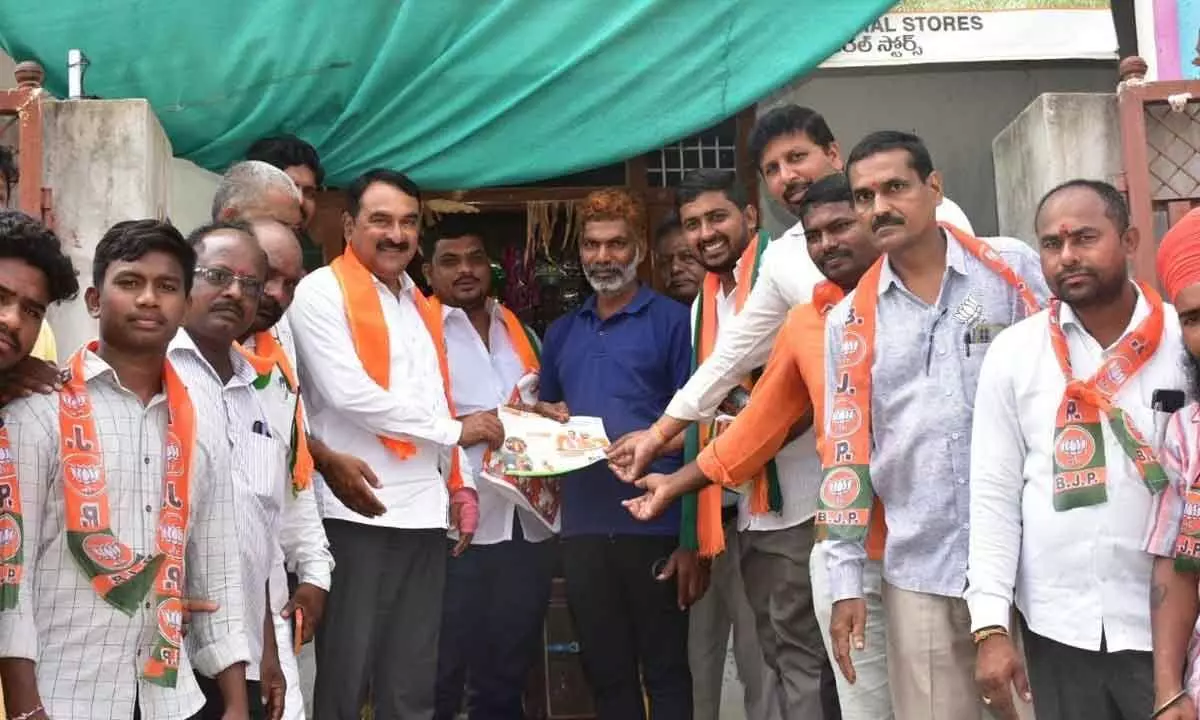 Warangal Urban Cooperative Bank chairman and BJP leader Errabelli Pradeep Rao explaining about the achievements of Modi Government to a denizen in Warangal as part of BJP’s Maha Jansampark Abhiyan on Thursday