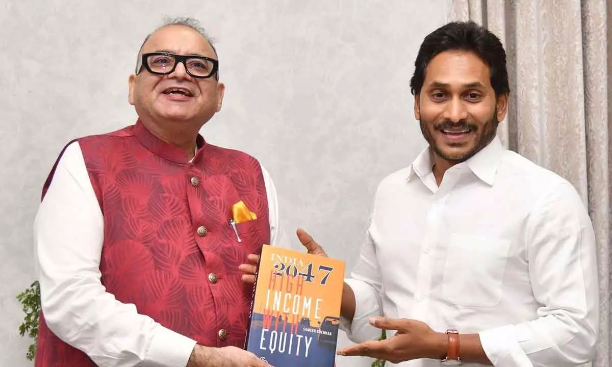 SKOCH Group chairman Sameer Kochhar presents a copy of his book to Chief Minister Y S Jagan Mohan Reddy at his camp office in Tadepalli on Thursday