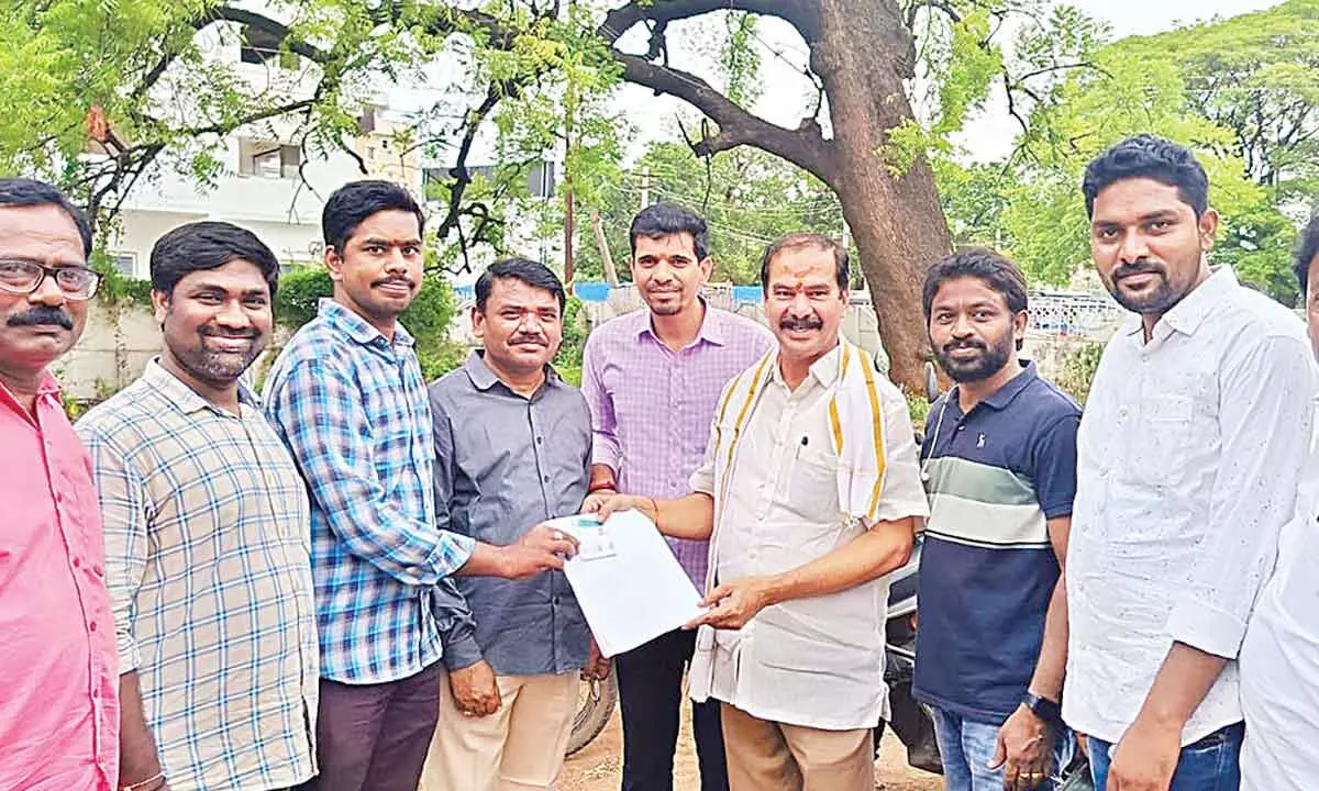 Chief Whip D Vinay Bhaskar giving away the marriage benefit proceedings to a worker in Hanumakonda on Friday