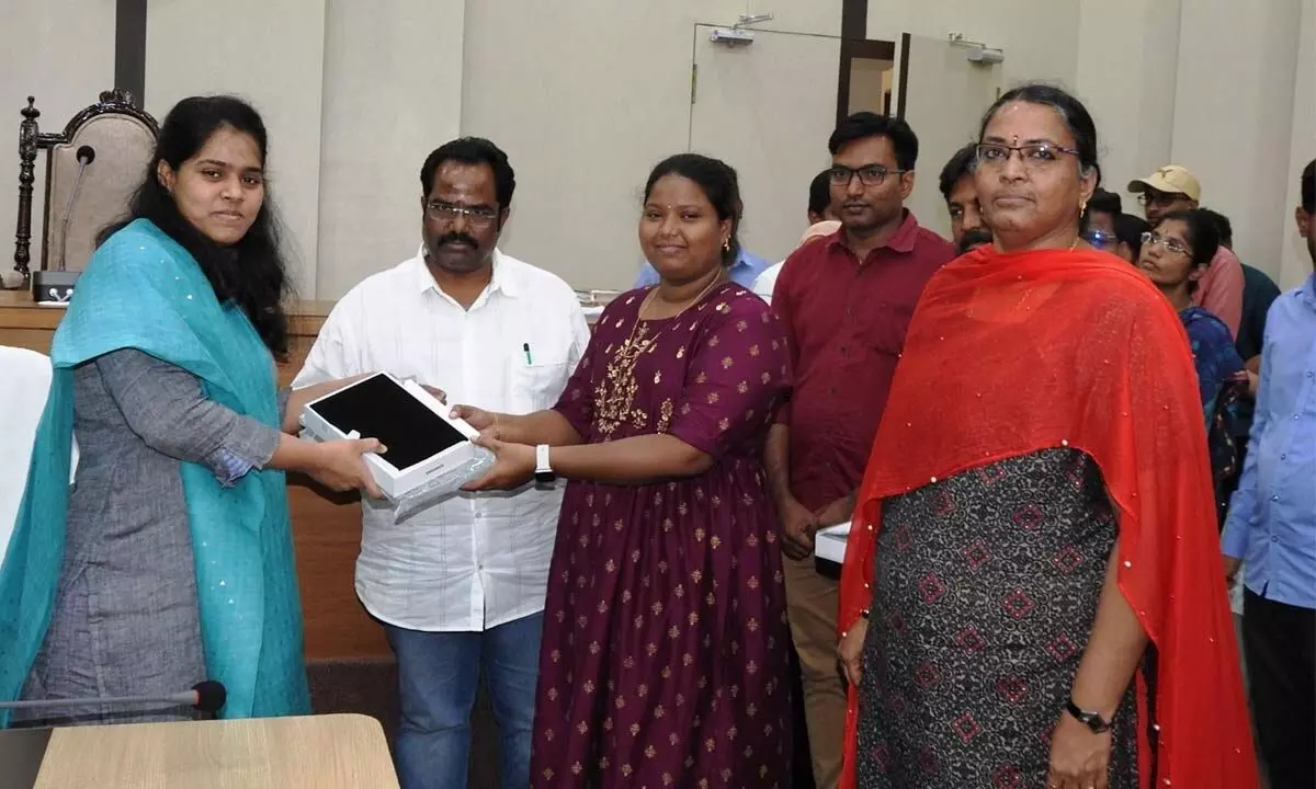 GMC Commissioner Kirthi Chekuri distributing tabs to the planning secretaries in Guntur on Monday